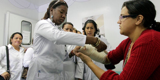 Dr. Yocelin Macias of Cuba attends to a patient during a training session at a health clinic in a low-income neighborhood in