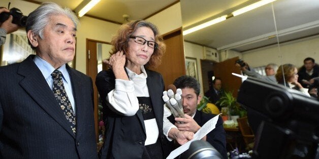 Junko Ishido (C) mother of Kenji Goto, speaks to reporters while her husband Yukio Ishido (L) stands beside her at their home