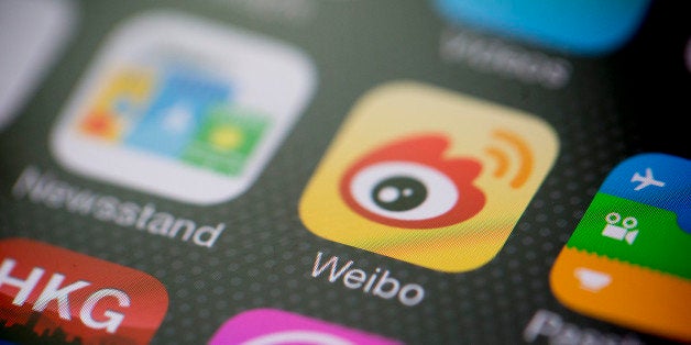 Sina Corp.'s Sina Weibo microblogging service app icon is displayed on an Apple Inc. iPhone 5s in an arranged photograph in H