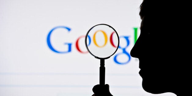 BERLIN, GERMANY - JUNE 02: A silhouette of a man and a magnifying glass is seen in front of a screen on which the Google sear