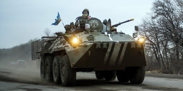 Ukrainian servicemen ride an Armoured Personnel Vehicle (APC) near Artemivsk on February 5, 2015. German Chancellor Angela Merkel and French President Francois Hollande touched down in Kiev today with a new peace plan to stop an upsurge in fighting in east Ukraine. AFP PHOTO/ VOLODYMYR SHUVAYEV (Photo credit should read VOLODYMYR SHUVAYEV/AFP/Getty Images)