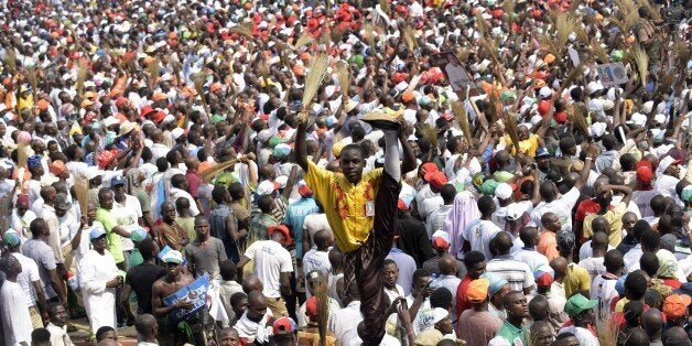 A supporter of Nigeria's leading opposition All Progressive Congress (APC) stands on the head of another man during a campaign rally at the Taslim Balogun Stadium in Lagos on January 30, 2015. Nigeria's main opposition party APC, which is expected to push the Peoples Democratic Party (PDP) close at the February 14 presidential and parliamentary vote, on January 29 accused the government of blocking foreign journalists from covering next month's elections and urged international monitors to press for access. AFP PHOTO / PIUS UTOMI EKPEI (Photo credit should read PIUS UTOMI EKPEI/AFP/Getty Images)