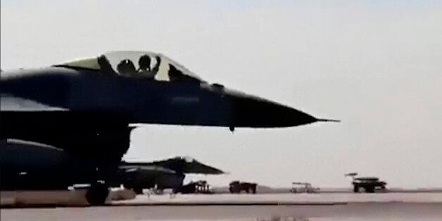 In this image made from Wednesday, Feb. 4, 2015, video provided by Jordanian military via Roya TV, an air force pilot raises his arm as he taxis his jet at Mowafak Al-Salti airbase in Azraq, Jordan. The military carried out airstrikes on Islamic State weapons depots and training sites on Thursday and Friday. King Abdullah II has thrust Jordan to the center of the war against the Islamic State group with his pledge of relentless retaliation for the killing of one of his pilots. (AP Photo/Jordanian military via Roya TV)