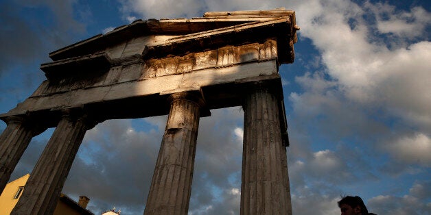 A man walks in front of the Gate of the ancient Roman agora, in central Athens, Saturday, Feb. 7, 2015. Greek Premier Alexis Tsipras and his Finance Minister Yanis Varoufakis received a warm reception on some stops of their European tour, but not in lead lender and bailout enforcer Germany. And Greece doesn't have much time. Its current bailout agreement expires at the end of February and the European Central Bank announced this week it can no longer accept junk-rated Greek bonds as collateral for loans to the country's banks after Feb. 11. (AP Photo/Petros Giannakouris)