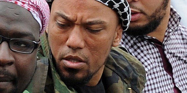 Picture taken on May 5, 2012 shows former German rapper Denis Cuspert (C) among salafi in Bonn, Germany. Denis Mamadou Cuspert, who rapped under the name Deso Dogg but took on the name Abu Talha al-Almani in Syria, was initially reported to have been killed in a suicide attack Sunday in an eastern province but hours later some retracted the claim, saying he was still alive. AFP PHOTO /DPA/ HENNING KAISER GERMANY OUT (Photo credit should read HENNING KAISER/AFP/Getty Images)