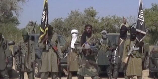 This Friday Oct. 31, 2014 image taken from video by Nigeria's Boko Haram terrorist network, the leader of Nigeria's Islamic extremist group Boko Haram, center, has denied agreeing to any cease-fire with the government and said Friday more than 200 kidnapped schoolgirls all have converted to Islam and been married off. (AP Photo)