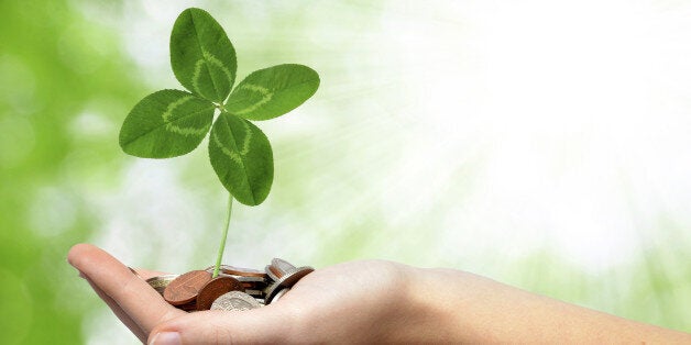 woman's hand are holding a money with clover on green background