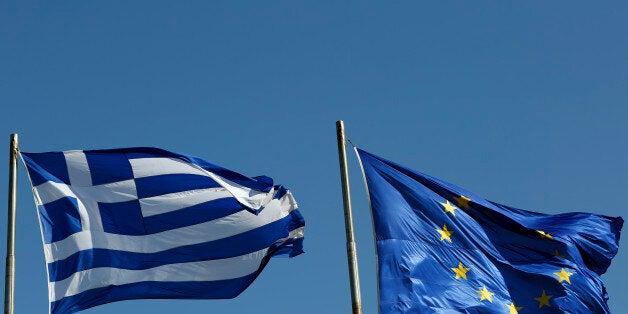 A Greek national flag, left, flies alongside a European Union (EU) flag in Athens, Greece, on Thursday, Feb. 19, 2015. German