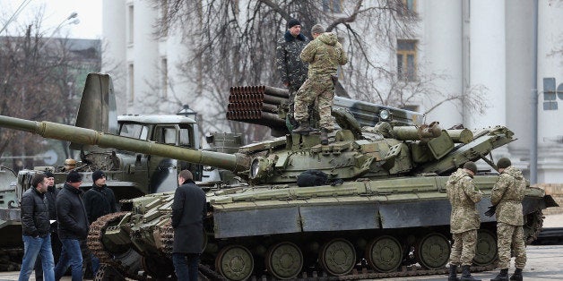 KIEV, UKRAINE - FEBRUARY 22: Security forces inspect a heavy tank and a rocket launcher truck that are part of an exhibition
