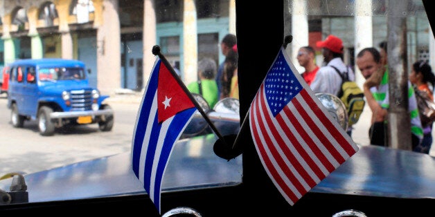 Miniature flags representing Cuba and the U.S. are displayed on the dash of an American classic car in Havana, Cuba, Friday,