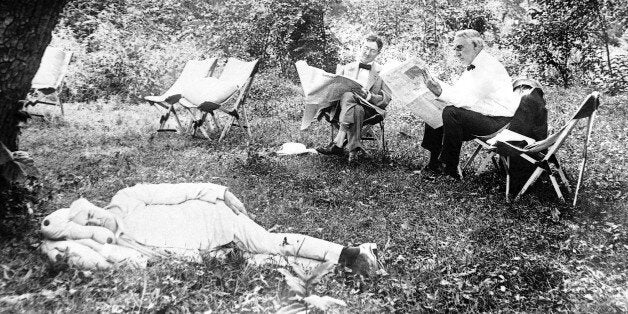 Thomas A. Edison sleeps, while President Warren Harding and tire magnate Harvey Firestone read newspaper in 1921. (AP Photo)