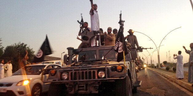 FILE - In this June 23, 2014, file photo, fighters from the Islamic State group parade in a commandeered Iraqi security force