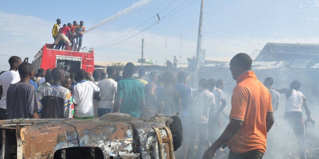 FILE - In this Tuesday, July , 2014 file photo, People gather at the scene of a car bomb explosion, at the central market, in Maiduguri, Nigeria. Suspected Islamic extremists struck two state capitals in northeast Nigeria simultaneously Monday dec. 1, 2014 , with twin blasts exploding at a crowded market in Maiduguri city and explosions and gunshots erupting in Damaturu. Trader Bala Dauda said victims were missing limbs and dripping blood at the Maiduguri market, the same one where two female suicide bombers killed scores of people a week ago. (AP Photo/Jossy Ola File)