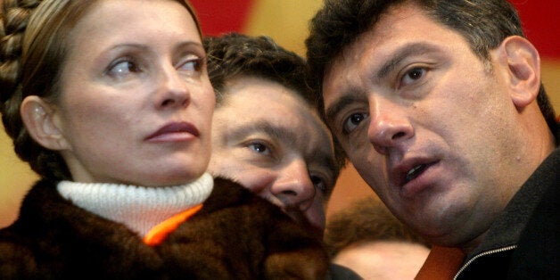 FILE - In this Nov. 22, 2004 file photo, Boris Nemtsov, a charismatic Russian opposition leader and sharp critic of President Vladimir Putin, right, listens to Petro Poroshenko while Yulia Tymoshenko, left, looks on during a street protest in downtown Kiev Ukraine. Nemtsov was gunned down Saturday, Feb. 28, 2015 near the Kremlin, just a day before a planned protest against the government. (AP Photo/Efrem lukatsky)