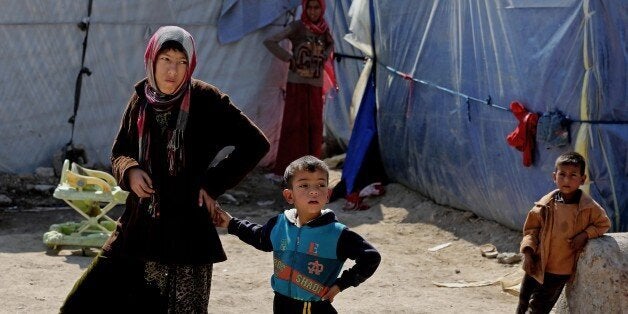 Iraqi refugees who fled from Tikrit and other towns after the advance of Islamic militants, settle at a camp for displaced Iraqis outside Baghdad, Iraq, Thursday, Feb. 19, 2015. (AP Photo/Karim Kadim)