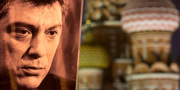 A portrait of Boris Nemtsov, a charismatic Russian opposition leader and sharp critic of President Vladimir Putin, who was gunned down on Friday, Feb. 27, 2015 near the Kremlin, seen with St. Basil's Cathedral is in the background in Moscow, Russia, Monday, March 2, 2015. The investigation into the killing of Boris Nemtsov, a fierce critic of Russian President Vladimir Putin who was gunned down not far from the Kremlin, faced conflicting reports Monday about possible surveillance footage of his slaying. Words on a portrait reading 'Fight!' (AP Photo/Alexander Zemlianichenko)