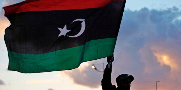 A Libyan waves the national flag during commemorations to mark the second anniversary of the revolution that ousted Moammar Gadhafi in Benghazi, Libya, Friday, Feb, 15, 2013. (AP Photo/Mohammad Hannon)