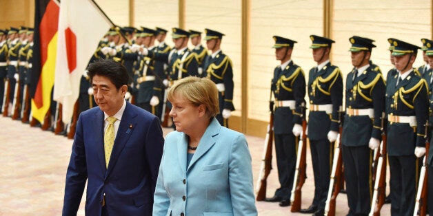 German Chancellor Angela Merkel, second from left, accompanied by Japanese Prime Minister Shinzo Abe, reviews a guard of honor prior to their meeting at Abe's official residence in Tokyo Monday, March 9, 2015. Merkel is on a two-day visit as part of a series of bilateral meetings with G-7 leaders ahead of a June summit in Germany. (AP Photo/Kazuhiro Nogi, Pool)