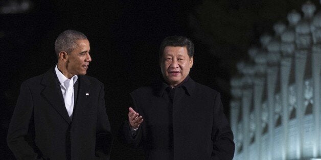 US President Barack Obama (L) walks with China's President Xi Jinping at the Zongnanhai leaders compound, ahead of a dinner i