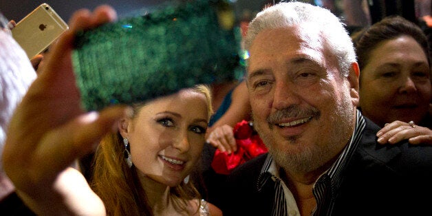 Celebrity Paris Hilton, left, takes a selfie with Fidel Castro Diaz-Balart, son of Cuba's leader Fidel Castro during the gala dinner of the 17th Cigar Festival in Havana, Cuba, Friday, Feb. 27, 2015. (AP Photo/Ramon Espinosa)