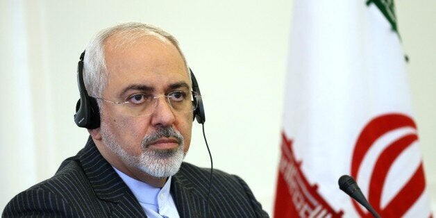 Iranian Foreign Minister Mohammad Javad Zarif listens to the translation of a question at a press conference with his Italian