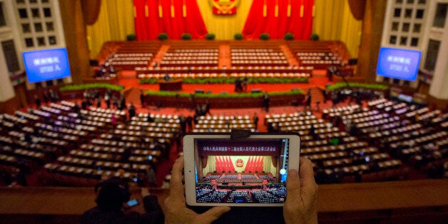 A delegate takes a photo before a plenary session of the National People's Congress in the Great Hall of the People in Beijin