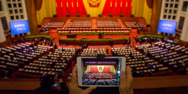 A delegate takes a photo before a plenary session of the National People's Congress in the Great Hall of the People in Beijing, Thursday, March 12, 2015. (AP Photo/Ng Han Guan)