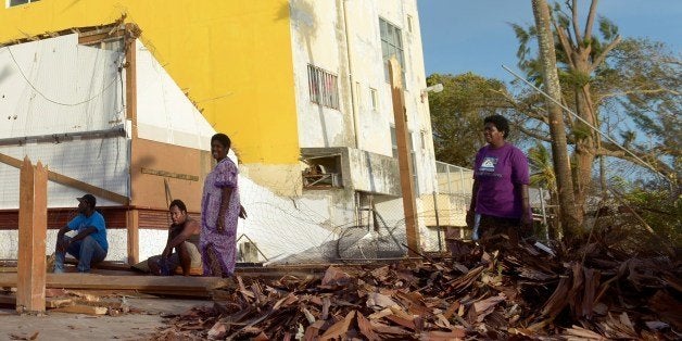 ALTERNATIVE CROPThis photo taken on March 16, 2015 shows residents assessing the damages in devastated Port-Vila, in cyclone-ravaged Vanuatu after Super Tropical Cyclone Pam tore through on March 13, packing wind gusts of up to 320 kilometres (200 miles) an hour. Aid agencies on March 16 described conditions in cyclone-ravaged Vanuatu as among the most challenging they have ever faced, as the Pacific nation's president blamed climate change for worsening the devastation. AFP PHOTO / FRED PAYET (Photo credit should read FRED PAYET/AFP/Getty Images)