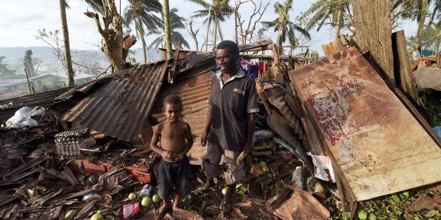 PORT VILA, VANUATU - MARCH 16: Samuel stands with his father Phillip in what remains of their family home on March 16, 2015 in Port Vila, Vanuatu. Cyclone Pam has hit South Pacific islands on Saturday with hurricane force winds, huge ocean swells and flash flooding and has caused severe damage to housing. Aid agencies say it could be one of the worst disasters ever to hit the region. (Photo by Dave Hunt-Pool/Getty Images)