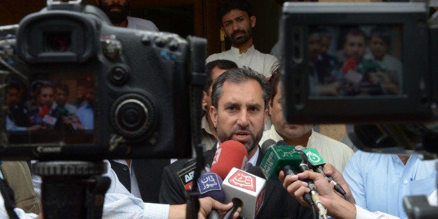 Samiullah Afridi (C), lawyer for Pakistani doctor Shakeel Afridi, who assisted the CIA in their hunt for Osama bin Laden, speaks with the media after a hearing in Peshawar on October 30, 2013. Shakeel Afridi was arrested after US troops killed bin Laden in May 2011 in the town of Abbottabad, where Afridi set up a fake vaccination programme in the hope of obtaining DNA samples to identify the Al-Qaeda leader. AFP PHOTO/ A MAJEED (Photo credit should read A. MAJEED/AFP/Getty Images)