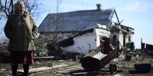 An elderly woman stands close to her damaged house in Nikishyne, south east of Debaltseve March 11, 2015. The town was levelled in fighting between Ukrainian troops and soldiers of the self-proclaimed Donetsk People's Republic (DNR) when the DNR made a push for Debaltseve. AFP PHOTO / JOHN MACDOUGALL (Photo credit should read JOHN MACDOUGALL/AFP/Getty Images)