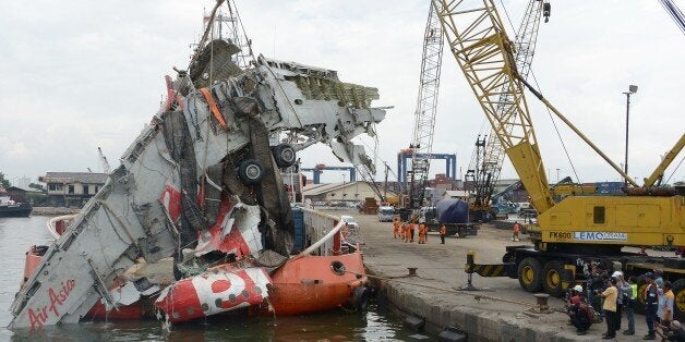 A crane is used to lift the fuselage of the crashed AirAsia QZ8501 plane at the Tanjung Priok port in Jakarta on March 2, 2015. Indonesia has retrieved the final major part of the fuselage of an AirAsia jet that crashed into the Java Sea in December, killing all 162 people on board, officials said on February 28. AFP PHOTO / ADEK BERRY (Photo credit should read ADEK BERRY/AFP/Getty Images)