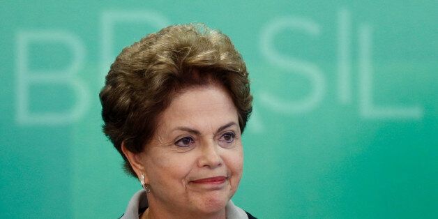 Brazil's President Dilma Rousseff smiles as she arrives for a government ceremony at the Planalto presidential palace in Brasilia, Brazil, Monday, March 16, 2015. Massive protests calling for Rousseff's impeachment on Sunday have narrowed her options to fend off political and economic crises, but her ouster remains highly unlikely, analysts said Monday. (AP Photo/Eraldo Peres)