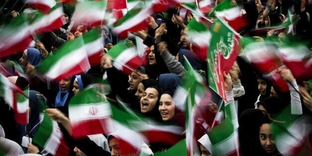 Iranian schoolgirls wave their national flag during the 36th anniversary of the Islamic revolution in Tehran's Azadi Square (
