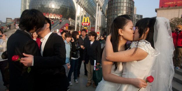 In a picture taken on March 8, 2011 gay couples kiss during their ceremonial 'wedding' as they try to raise awareness of the issue of homosexual marriage, in Wuhan, in central China's Hubei province. Homosexuality was considered a mental disorder in China until 2001. Today, gays face crushing social and family pressure and many remain in the closet as a result, despite gradual steps towards greater acceptance. CHINA OUT AFP PHOTO (Photo credit should read STR/AFP/Getty Images)
