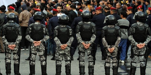 The Jordanian security surrounds the demonstration of the Muslim Brotherhood in downtown Amman, Jordan, Jordan, Friday, Nov. 28, 2014 in solidarity with Palestinians people and against last week's arrest of deputy leader of the Muslim Brotherhood Zaki Bani Irsheid.(AP Photo/Raad Adayleh)