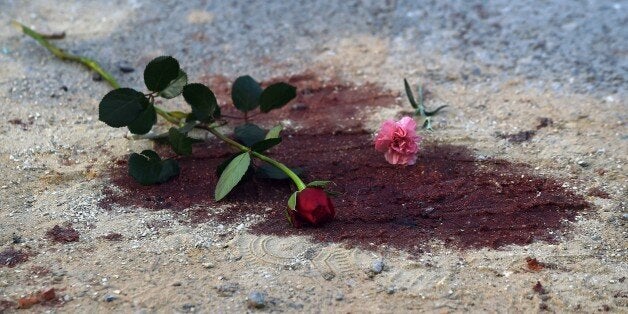 Roses are seen on bloodstains in front of the National Bardo Museum in Tunis on March 19, 2015 during a demonstration in soli