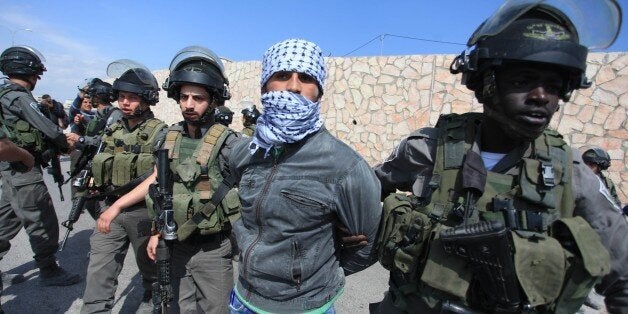 JERUSALEM, ISRAEL - MARCH 17: A Palestinian protest is taken into custody by Israeli security forces during a protest against the construction of new Jewish settlements in Abu Dis town of Jerusalem, Israel on March 17, 2015. (Photo by Issam Rimawi/Anadolu Agency/Getty Images)