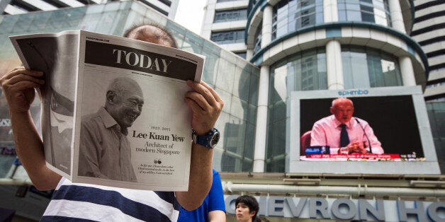 A monitor shows coverage of the death of Singapore's first elected Prime Minister Lee Kuan Yew as a man reads a special edition of a Today newspaper, produced by MediaCorp Press Ltd., at Raffles Place in Singapore, on Monday, March 23, 2015. Lee, who helped transform Singapore from a colonial trading center into one of Asia's most prosperous nations, has died. He was 91. Photographer: Nicky Loh/Bloomberg via Getty Images