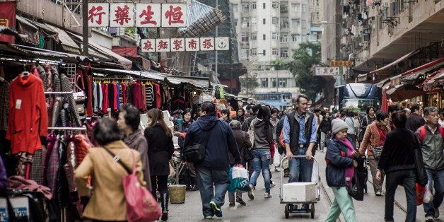 Pedestrians walk by the stalls of a street market in Hong Kong on January 15, 2013. Hong Kong Chief Executive Leung Chun-ying, who won office after he campaigned promising to improve the lives of poor and middle-class citizens, is to give his first policy address on January 16 amid discontent over issues including sky-high property prices and anti-Beijing sentiment. AFP PHOTO / Philippe Lopez (Photo credit should read PHILIPPE LOPEZ/AFP/Getty Images)