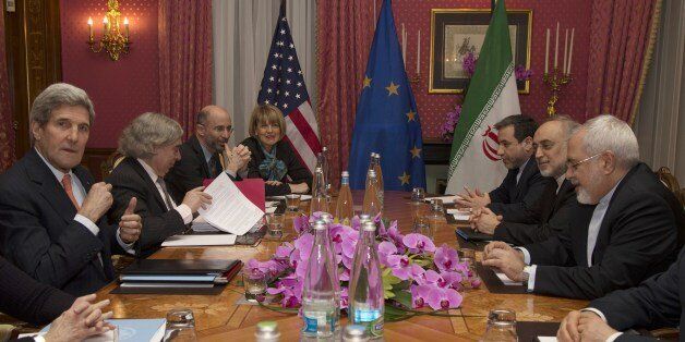 United States Secretary of State John Kerry (L) sits with his delegation during a negotiation meeting concerning Iran's nuclear program with Iran's Foreign Minister Javad Zarif (R) in Lausanne on March 19, 2015 as European Union Political Director Helga Schmid (4-L) looks onover. US and Iranian negotiators entered into a fourth day of tough talks towards a landmark nuclear deal, with Tehran's foreign minister talking down prospects for a breakthrough this week. US Secretary of State John Kerry and his Iranian counterpart have been haggling in Switzerland since Monday as they seek to agree the outlines of this potentially historic agreement by March 31.AFP PHOTO / POOL / Brian Snyder (Photo credit should read BRIAN SNYDER/AFP/Getty Images)
