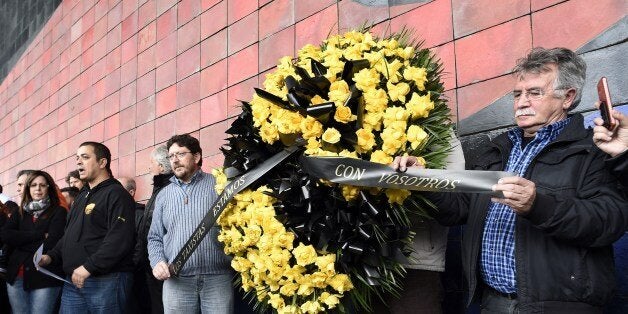 Employees of Barcelona's El Prat airport hold a wreath of flowers as they observe a minute of silence at noon to honour the victims of the crash of an Airbus A320, in El Prat de Llobregat, south of Barcelona on March 25, 2015. An Airbus A320 operated by Lufthansa's Germanwings budget airline coming from Barcelona and heading to Dusseldorf crashed on March 24, 2015 in a remote area of the French Alps, killing all 150 people on board. Spain declared three days of mourning and King Felipe VI cut short his first state visit to France on March 24 just minutes after it began when he heard news of the tragedy. AFP PHOTO/ LLUIS GENE (Photo credit should read LLUIS GENE/AFP/Getty Images)