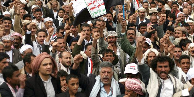 Houthi shiite rebels chant slogans during a protest near the site of a suicide bombing in Sanaa, Yemen, Thursday, Oct. 9, 2014. A suicide bomber struck at the center of the Yemeni capital of Sanaa on Thursday, setting off his explosives at a gathering of supporters of the rebel Shiite Houthis who recently overran the city, security officials said. Arabic on a banner at center reads,"God is great. Death to America. Death to Israel. A curse on the Jews. Victory to Islam." (AP Photo/Abdullrhman Huwais)