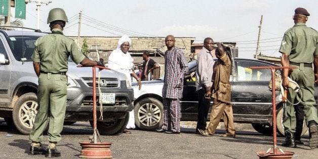 Nigerian security forces stand guard outside a polling station in Lagos during presidential elections on March 29, 2015. Nigeria's closely fought general election went into a second day on March 29 after failures in controversial new technology snarled the polling. AFP PHOTO / STRINGER (Photo credit should read -/AFP/Getty Images)