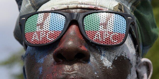 A man wears glasses adorned wit hthe logo of Nigeria's main opposition All Progressives Congress (APC) as residents await res