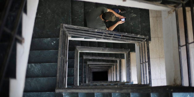 An Indian man sits on a hospital stairs and looks at his smartphone in New Delhi, India, Tuesday, March 24, 2015. India's top court reaffirmed people's right to free speech in cyberspace Tuesday by striking down a provision that had called for imprisoning people who send "offensive" messages by computer or mobile phone. The provision, known as Section 66A of the 2008 Information Technology Act, says sending such messages is a crime punishable by up to three years in prison. (AP Photo/Altaf Qadri)