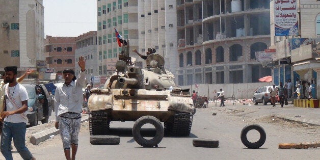Militiamen loyal to Yemen's President Abed Rabbo Mansour Hadi take positions at a street in Aden, Yemen, Thursday, April 2, 2