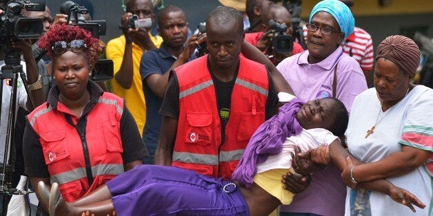 Members of the Red Cross carry a relative of one of the students massacred by Somalia's Shebab Islamists at a Kenyan university at the Chiromo funeral parlour in the Kenyan capital, Nairobi, on April 3, 2015. The bodies of dozens of students massacred by Somalia's Shebab Islamists at a Kenyan university in Garissa arrived in the capital today, as grieving relatives faced a desperate wait to receive the remains of their loved ones. AFP PHOTO / TONY KARUMBA (Photo credit should read TONY KARUMBA/AFP/Getty Images)