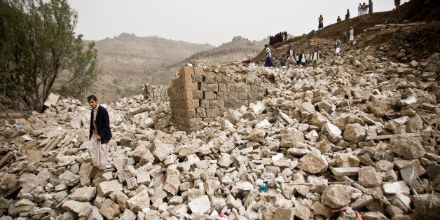 Yemenis stand amid the rubble of houses destroyed by Saudi-led airstrikes in a village near Sanaa, Yemen, Saturday, April 4,
