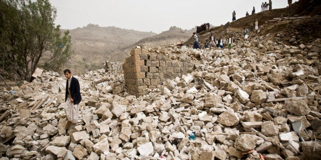 Yemenis stand amid the rubble of houses destroyed by Saudi-led airstrikes in a village near Sanaa, Yemen, Saturday, April 4, 2015. Since their advance began last year, the Shiite rebels, known as Houthis have overrun Yemen's capital, Sanaa, and several provinces, forcing the countryâs beleaguered President Abed Rabbo Mansour Hadi to flee the country. A Saudi-led coalition continued to carry out intensive airstrikes overnight and early Saturday morning targeting Houthi positions. (AP Photo/Hani Mohammed)